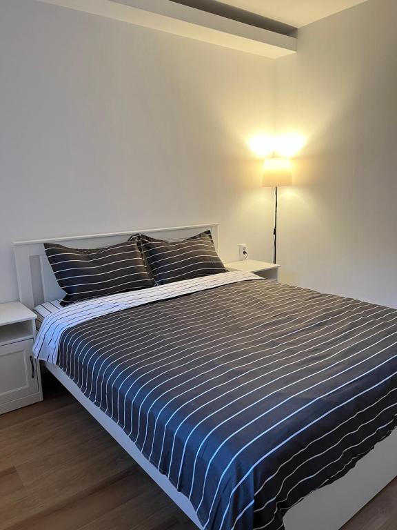 锡纳亚Accommode的一间卧室配有一张带蓝色和白色条纹棉被的床