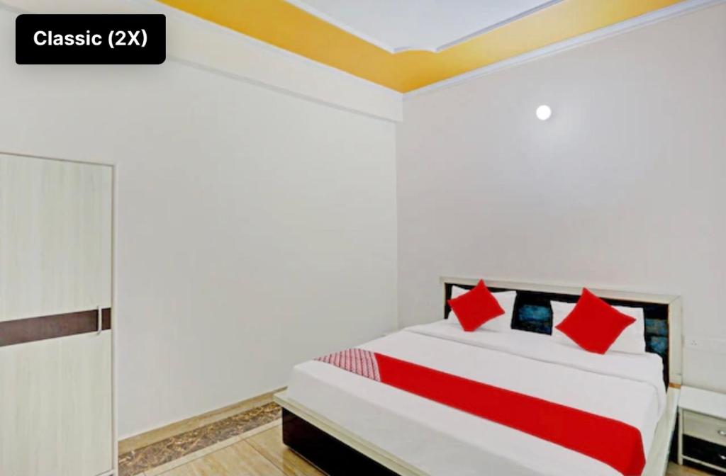 SikandraHotel NK guesthouse的卧室配有带红色枕头的大型白色床