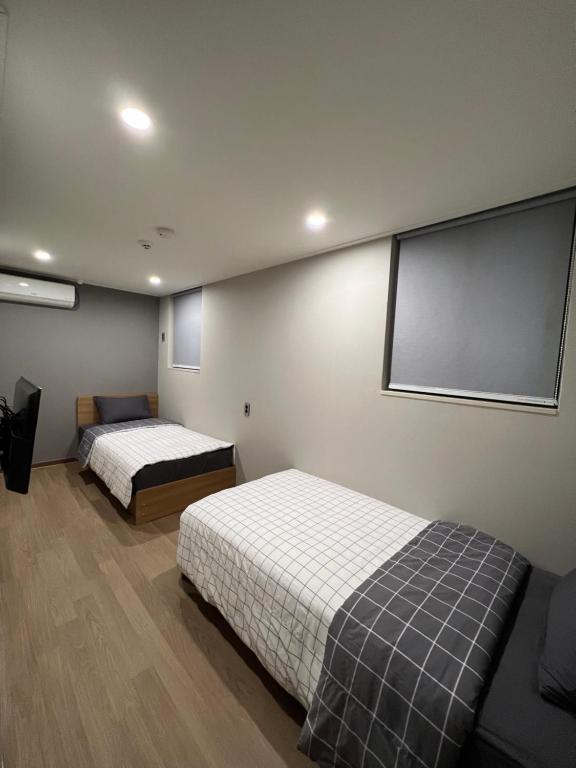 首尔Hao Guesthouse in Hongdae的带两张床和投影屏幕的房间