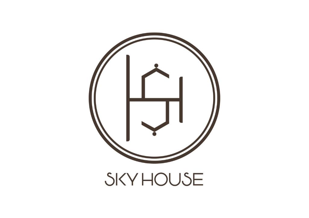 胡志明市Sky House Hostel的圆圈中反常房屋的标志