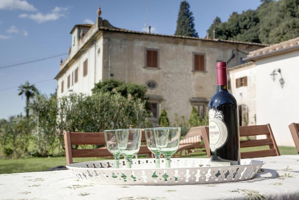 卡莱扎诺福特丽雅迪马西亚度假屋的桌子上摆放着一瓶葡萄酒和眼镜