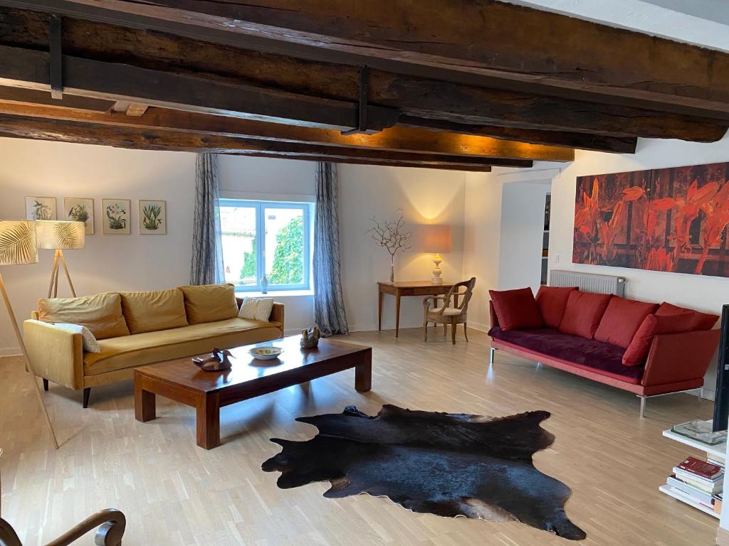 克卢尼Les Hauts de CLuny的客厅配有两张沙发和一张桌子