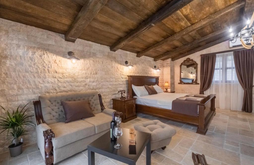 巴尔OLIVE QUEEN Rustic Villa的一间卧室配有一张床和一个沙发