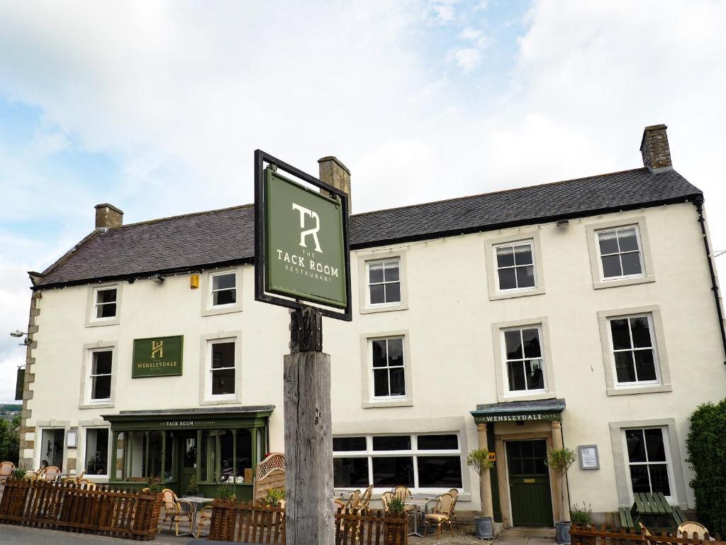 米德尔赫姆The Wensleydale Hotel的白色建筑前的街道标志