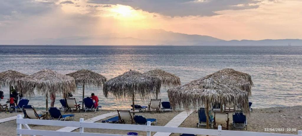 斯卡拉索提罗斯Villa Giotis Suite的海滩上设有椅子和草伞,还有大海