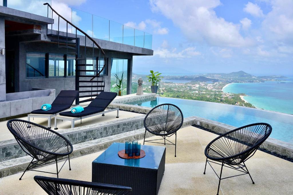 苏梅岛Paradise Villa Elysium的一个带桌椅的庭院和一个游泳池