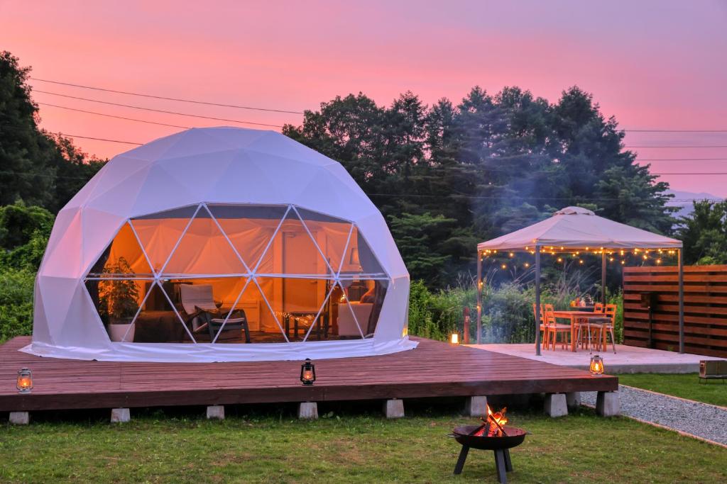 富士河口湖Glamping Resort Varie的冰屋帐篷配有桌子和烧烤架