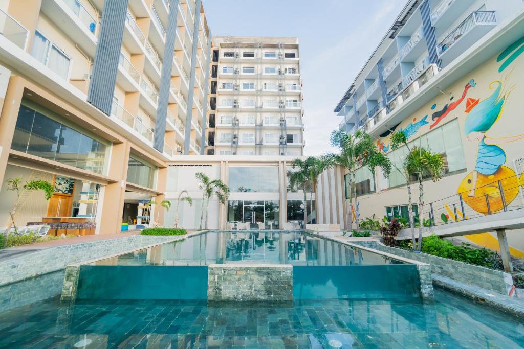 麦克坦Solea Palm Resort Mactan的一座建筑物中央的游泳池