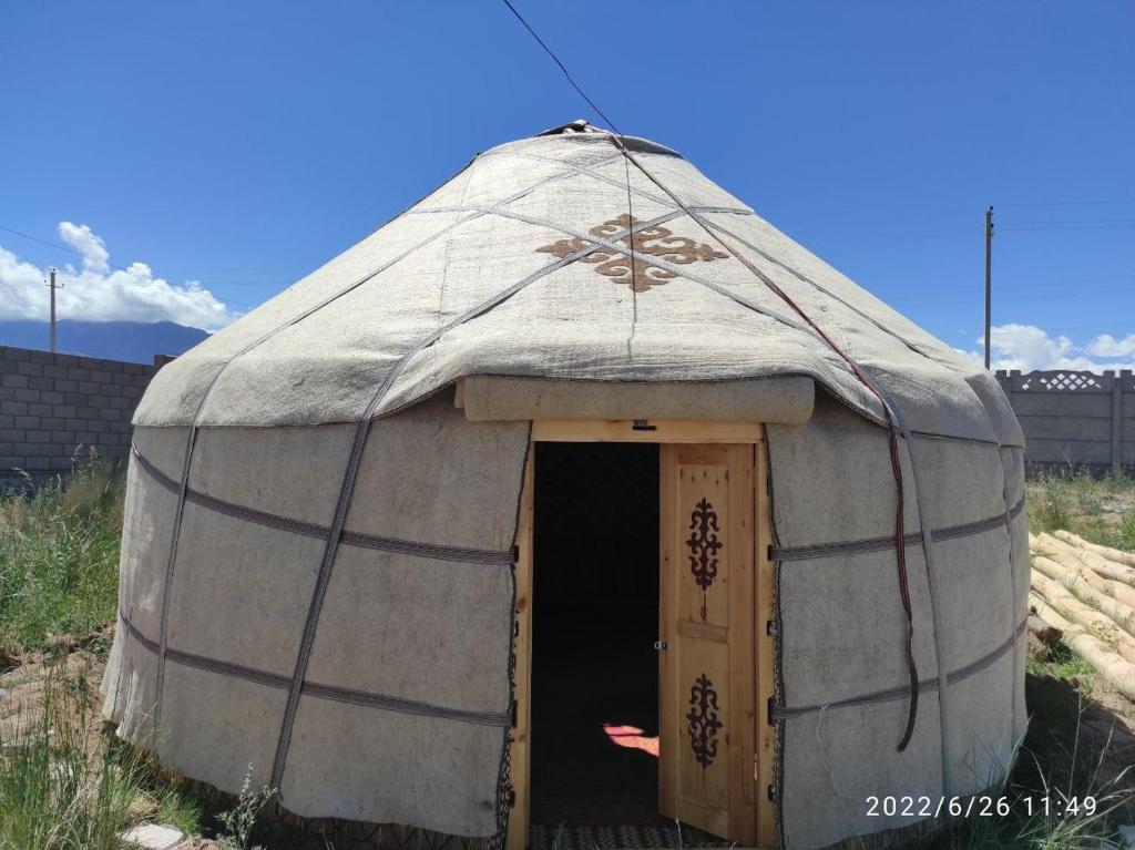 TongGuest house and Yurt camp "Ailuu"的田野上带门的大型圆顶帐篷