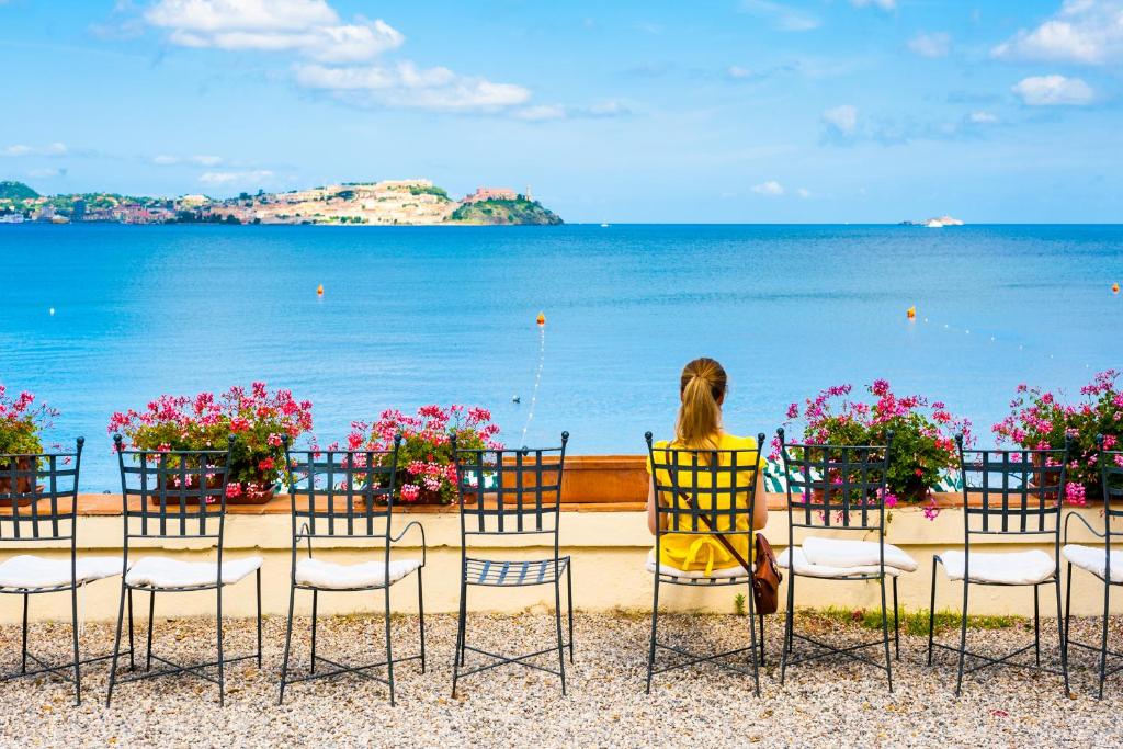 费拉约港奥托尼别墅酒店的坐在椅子上看着海洋的女人