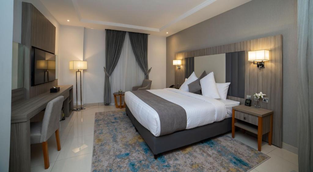 吉达Romera Hotel的酒店客房配有一张床、一张书桌和一张书桌。