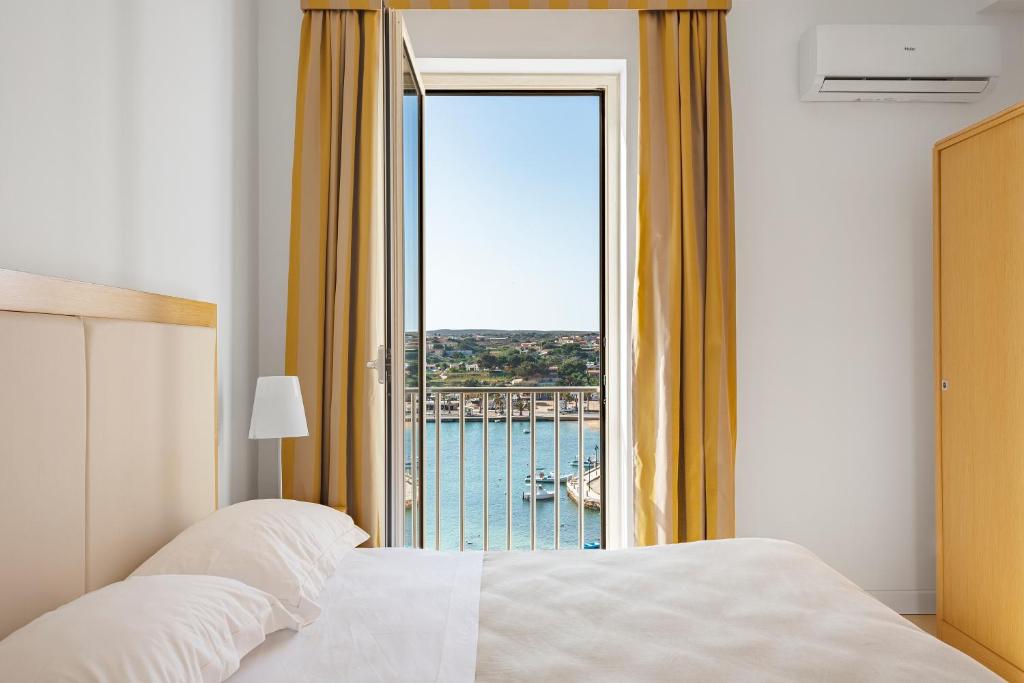 兰佩杜萨Hotel Vega的一间卧室配有一张床,享有海景