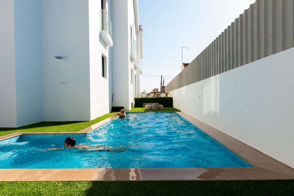 塞图巴尔Sport Hotel A Seleção的两个孩子在房子的游泳池玩耍