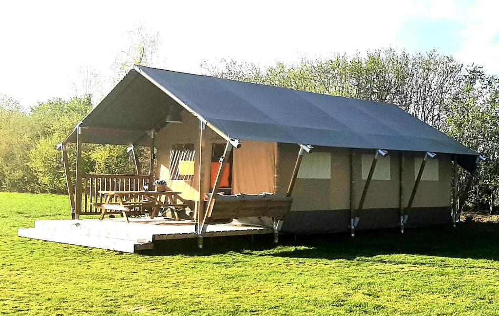 吕洛Safaritent Lodge 5的田野上带桌椅的帐篷