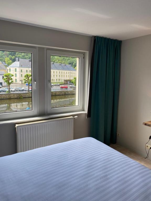 布永Hotel LA PLAGE的一间卧室设有一张床和两个窗户。