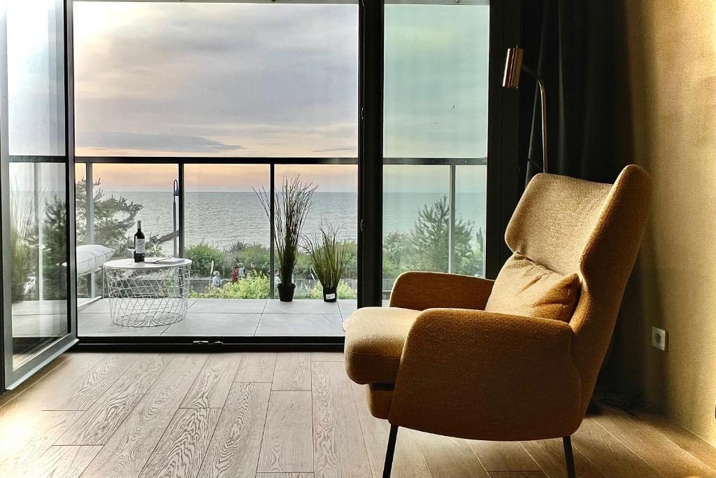 梅尔诺Tuż przy plaży - nowoczesny apartament z tarasem i pięknym widokiem na Bałtyk的客厅配有椅子,享有海景