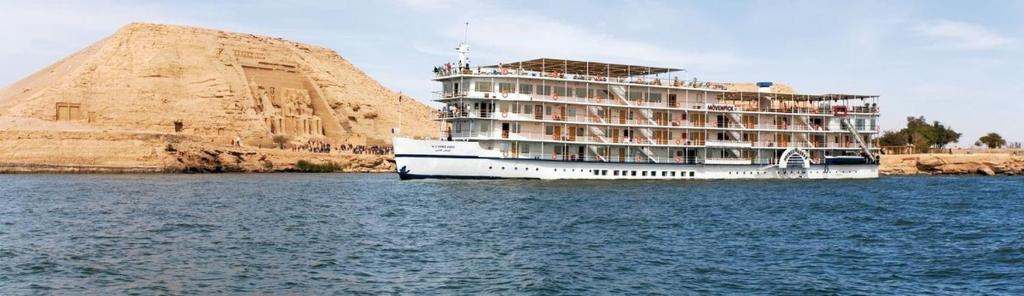 卢克索Mövenpick Prince Abbas Lake Nasser Monday Four Nights Aswan Friday Three nights Abu-Simbel的岩石旁边的水面上的游轮