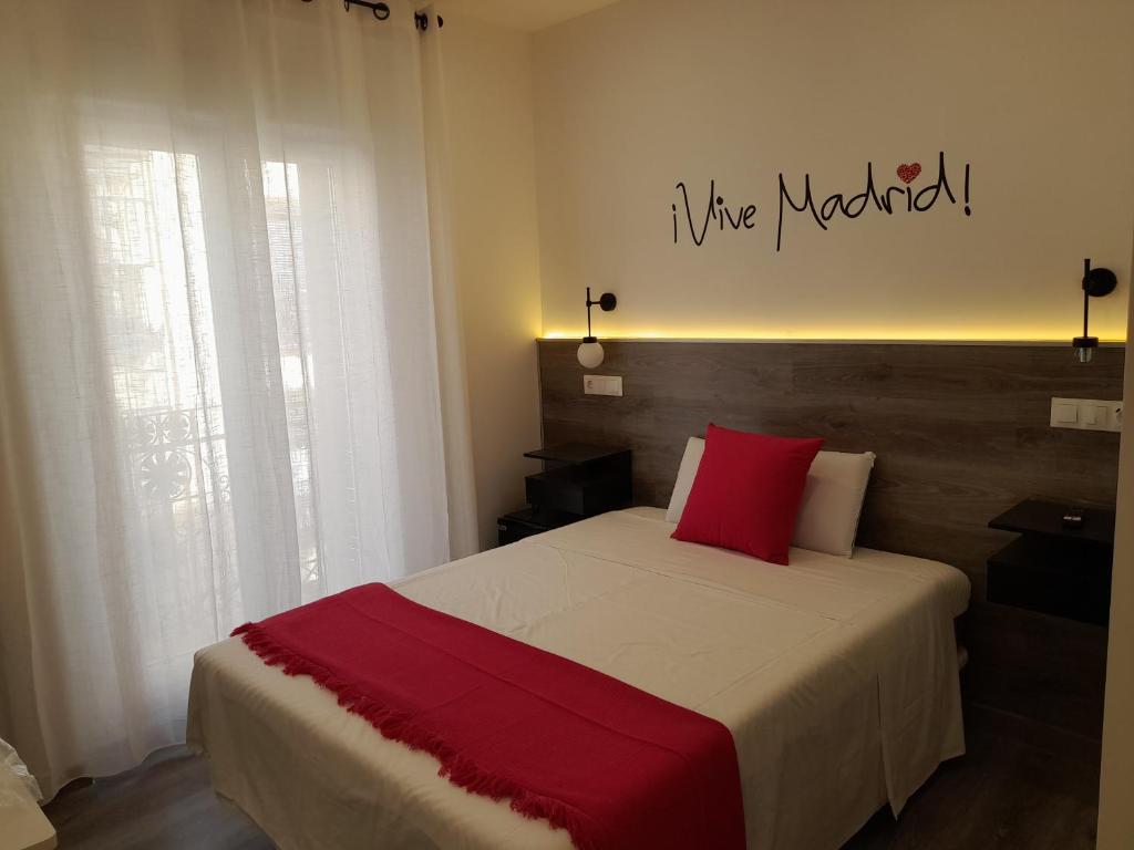 马德里CH Bueno的一间卧室配有一张带红色枕头的大床