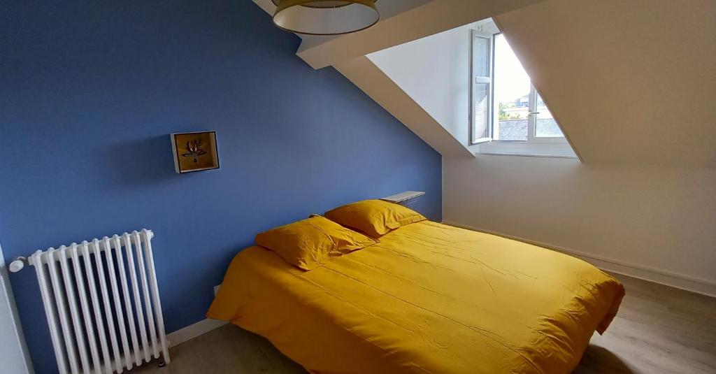 索米尔HISTOIRE DE LOIRE - LA TOUE的一间卧室设有黄色的床和窗户。