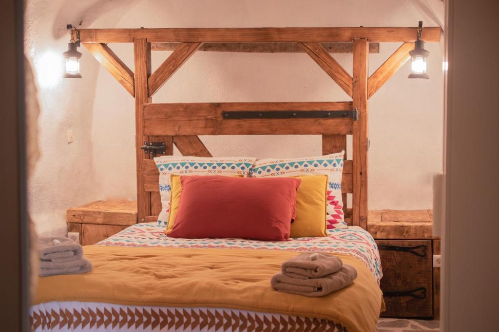 拉萨尔韦塔Ranch du Haut-Languedoc的一间卧室配有一张带毛巾的木床