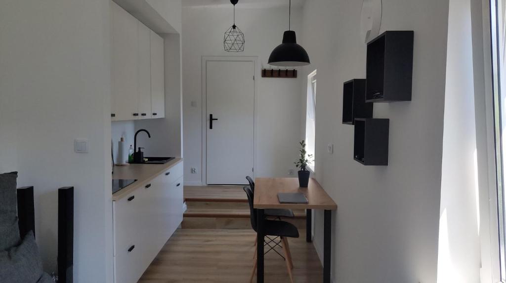 索波特Studio 4 Piętro II的一间设有桌子的客房和一间带白色墙壁的厨房