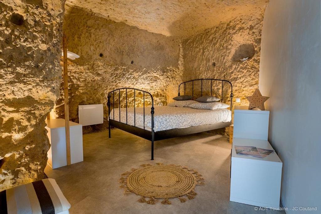武夫赖La cavée du coteau, petit cocon troglodytique的石头间内一间卧室,配有一张床