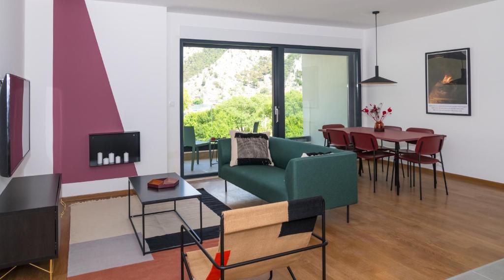 奥米什Rivus Apartments的客厅配有绿色沙发和桌子