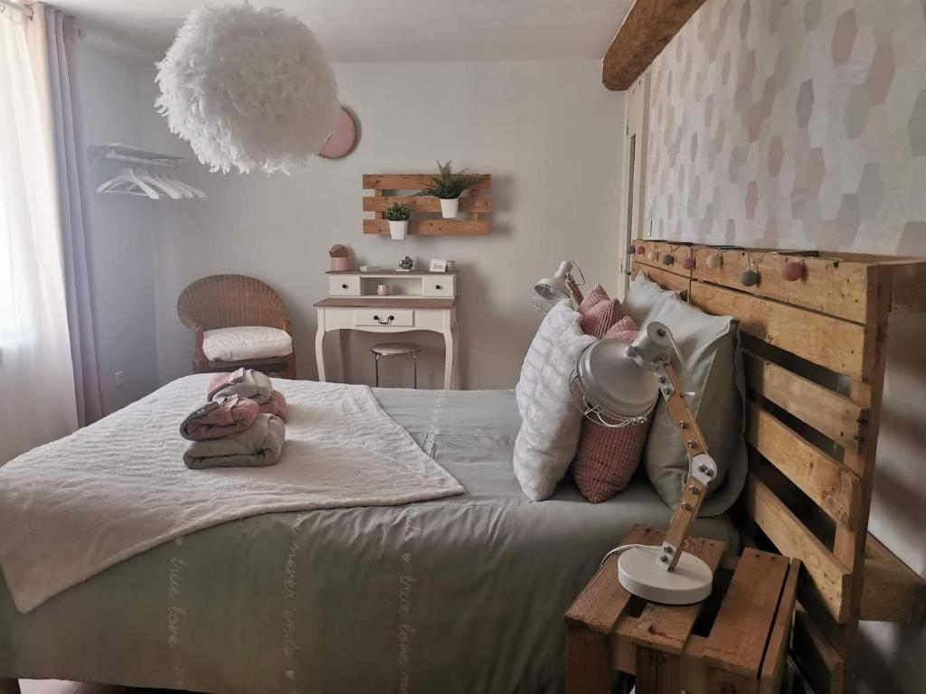 VertaizonChez Stéphane et Patricia的一间卧室配有一张带台灯和桌子的床