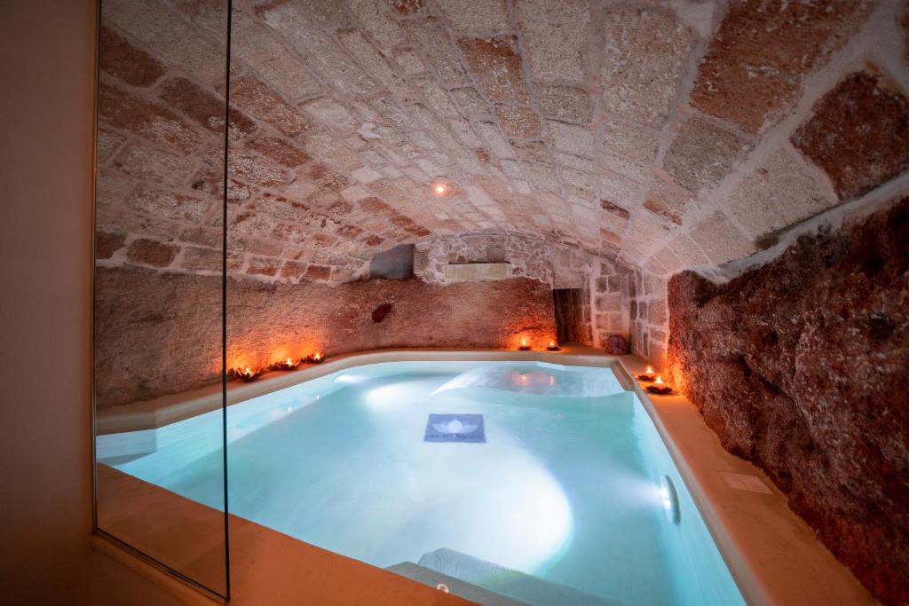 滨海波利尼亚诺Dimora Valmar Luxury Charm的石墙洞内的热水浴池