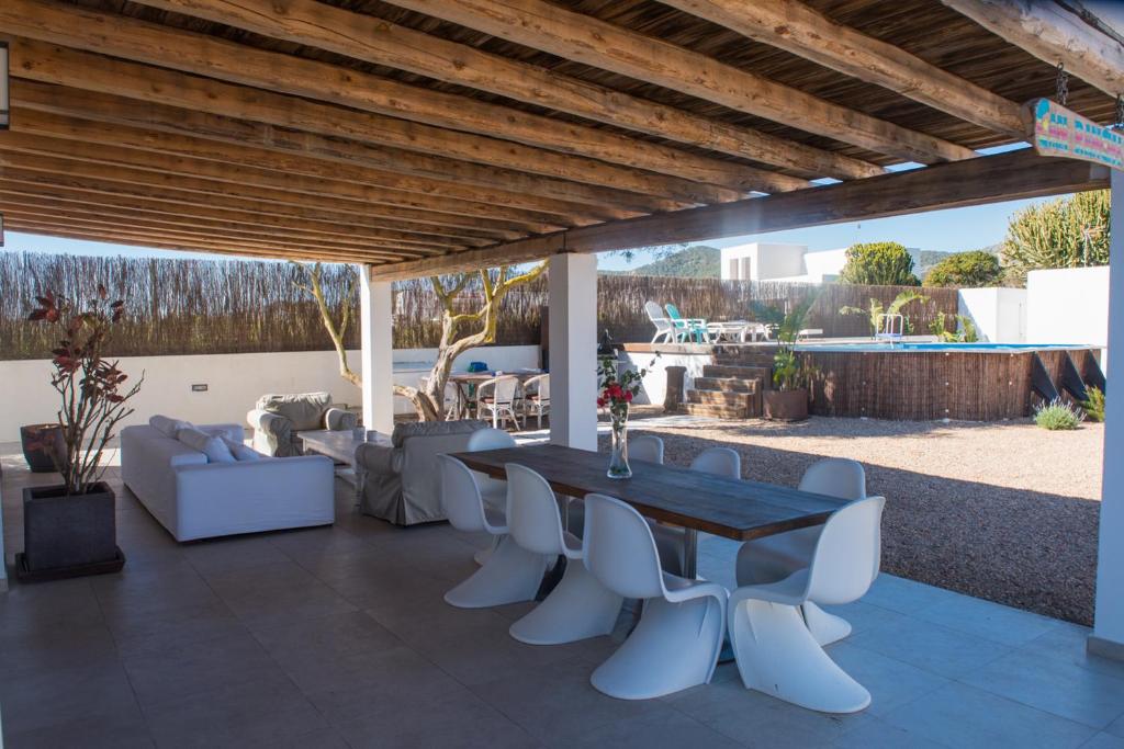 圣何塞德萨塔莱阿CASA ENTERA SA CALETA!!的庭院配有木桌和白色椅子