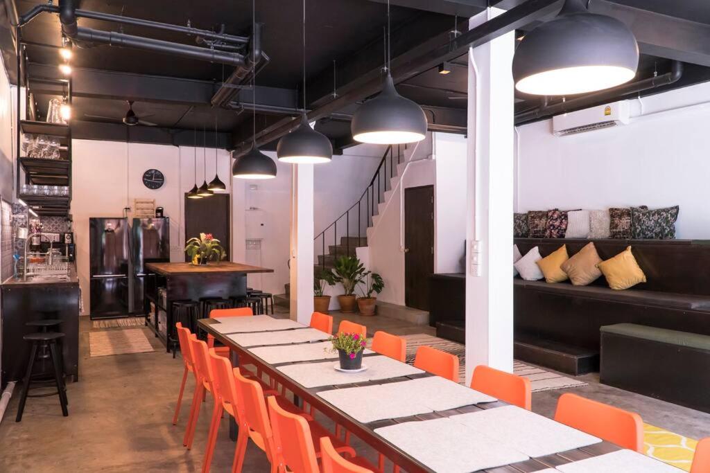 曼谷Beautiful Super Modern Gigantic Designer Home的一间带长桌和橙色椅子的用餐室
