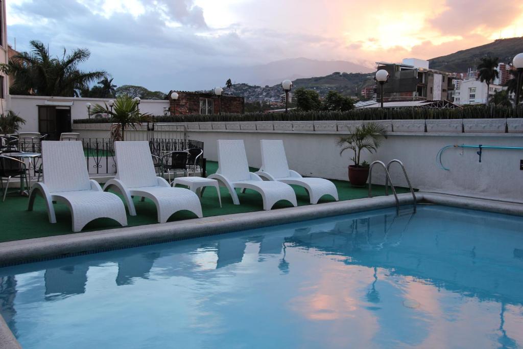 卡利圣费尔南多里尔酒店的游泳池旁的一排白色椅子