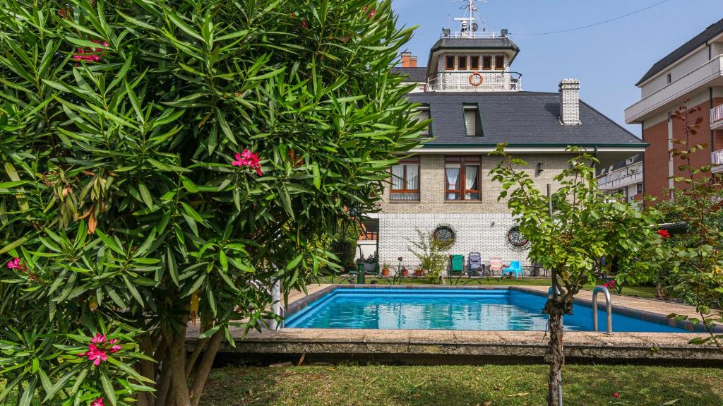 科林德雷斯Casa marinera con piscina y jardín.的一座带钟楼建筑前的游泳池