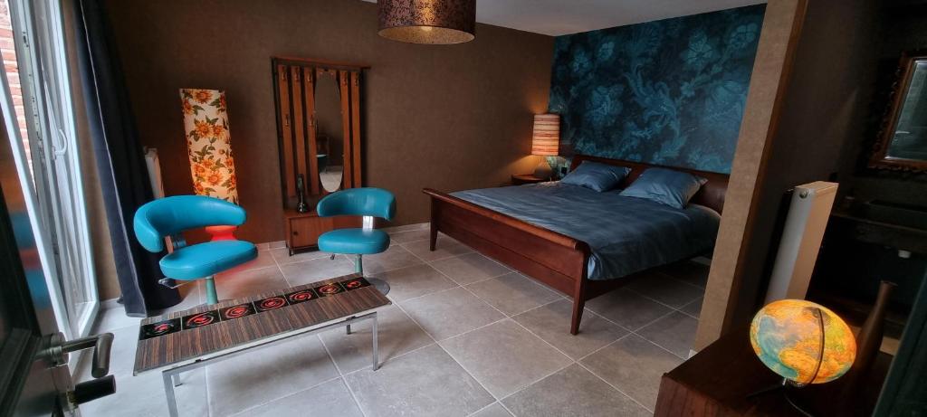 奥斯坦德Logies La Chèvre Folle的一间卧室配有一张床和两张蓝色椅子