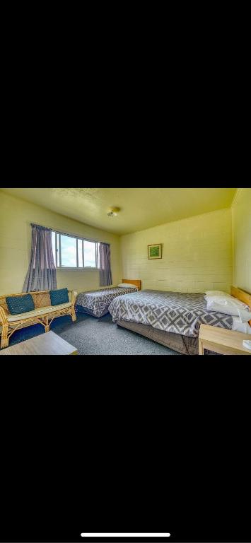Te KaoTekao Lodge的一间卧室设有两张床和窗户。