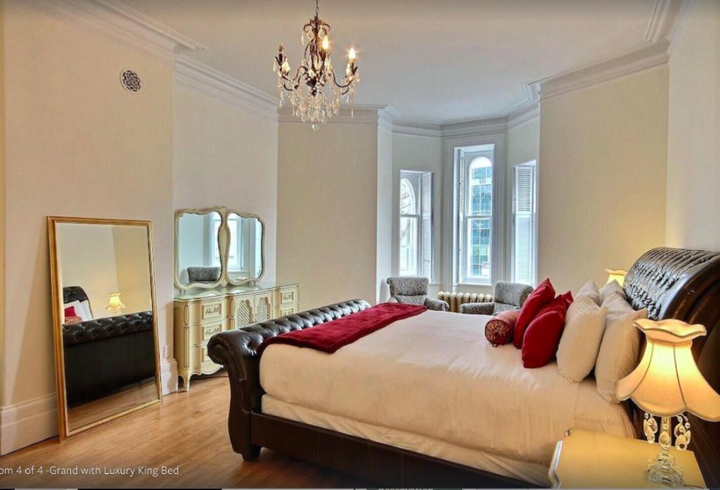 魁北克市Les Maisons Montcalm的一间卧室配有一张大床和镜子