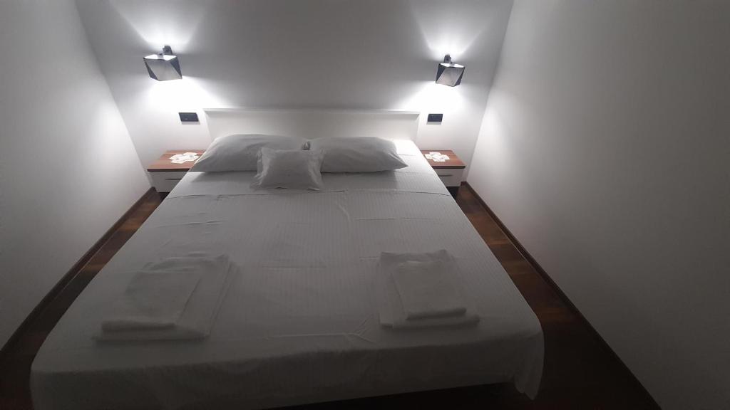 坎普尔Marija šimičić的一张大白色的床,房间有两个灯
