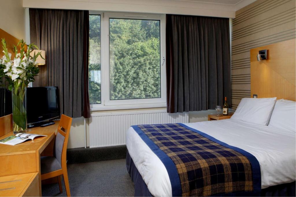 道格拉斯贝斯特韦斯特宫殿酒店&赌场的酒店客房配有一张床、一张书桌和一台电视。
