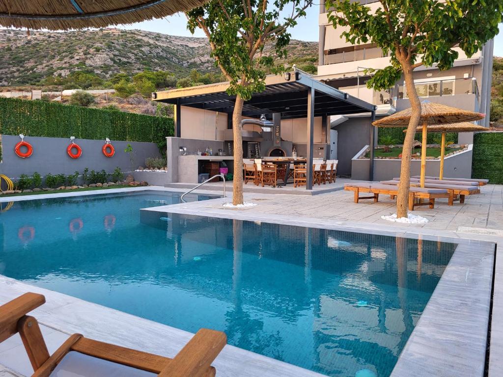萨罗尼扎''Stergiou Luxury Apartment 2nd Floor'' με κοινη πισινα的大楼旁的游泳池配有桌椅