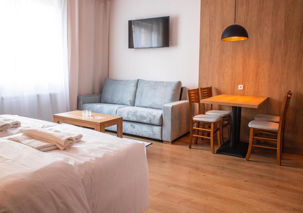 捷克布杰约维采Beseda的客房设有床、沙发和桌子。