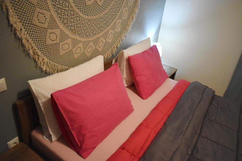 特里卡拉Rose's House的一张带红色和白色枕头的床