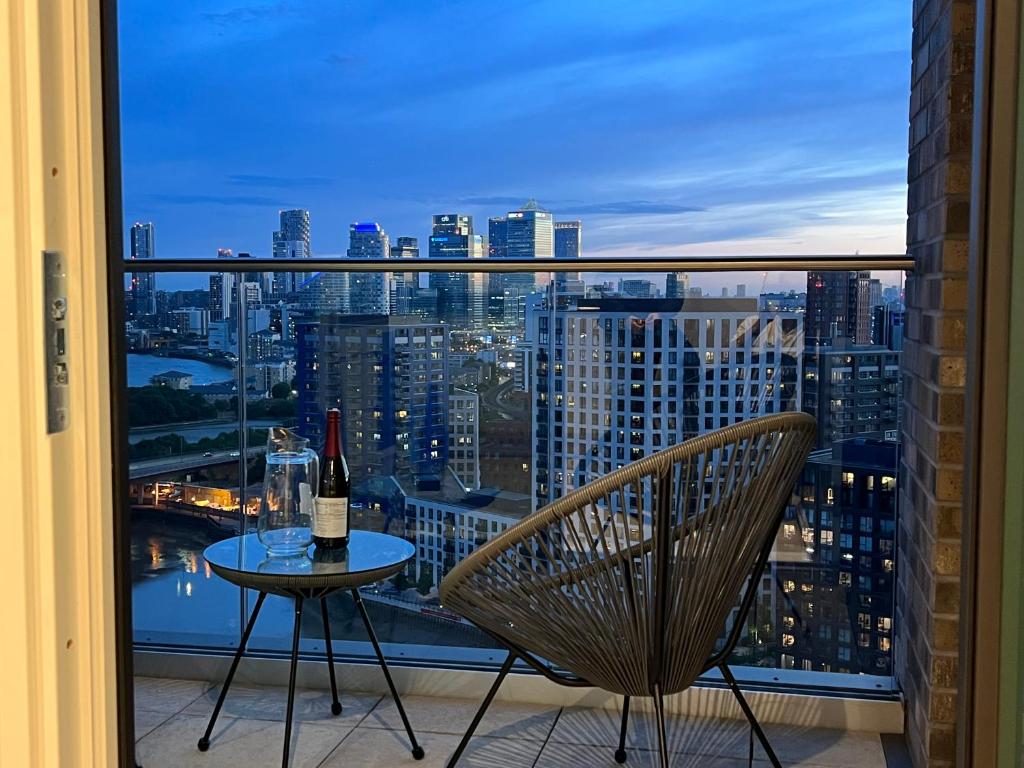 伦敦Luxury penthouse with stunning views near Canary Wharf的阳台上的桌子上摆放着一瓶葡萄酒