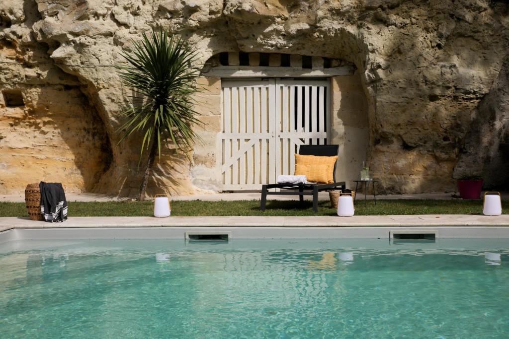 朗热Domaine du Val Sauvage的石墙前带游泳池的房子
