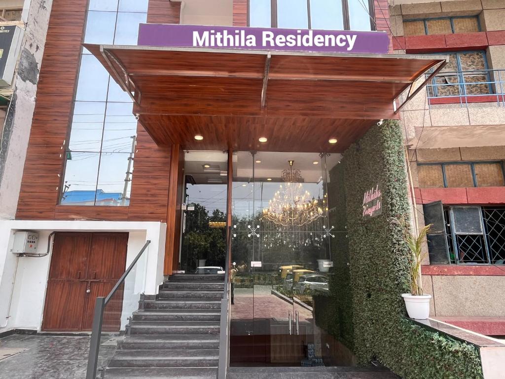 诺伊达Hotel Mithila Residency Noida - Couple Friendly Local IDs Accepted的一座带木门和楼梯的建筑的入口