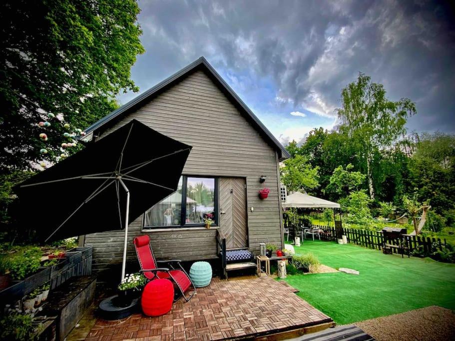 里加Amazing little house on an island with garden的草坪上带遮阳伞和椅子的房子