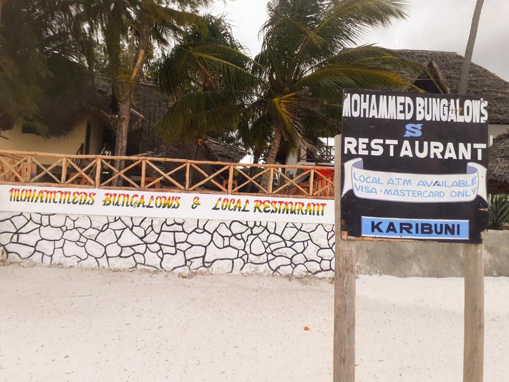 马特姆维Mohammed Bungalows and Restaurant的建筑前的海滩标志