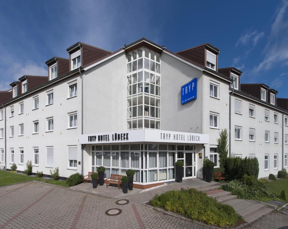 吕贝克吕贝克海蓝宝石温德姆特里普酒店的一座白色的大建筑,有火的标志