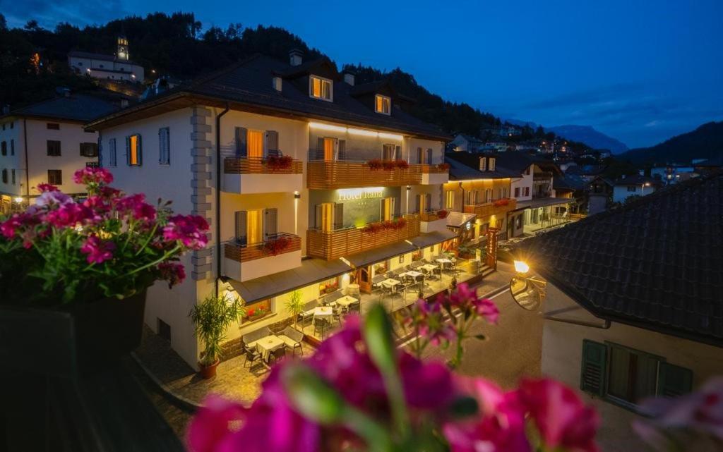 菲耶梅堡意大利酒店的享有建筑的夜间美景,并拥有粉红色的鲜花