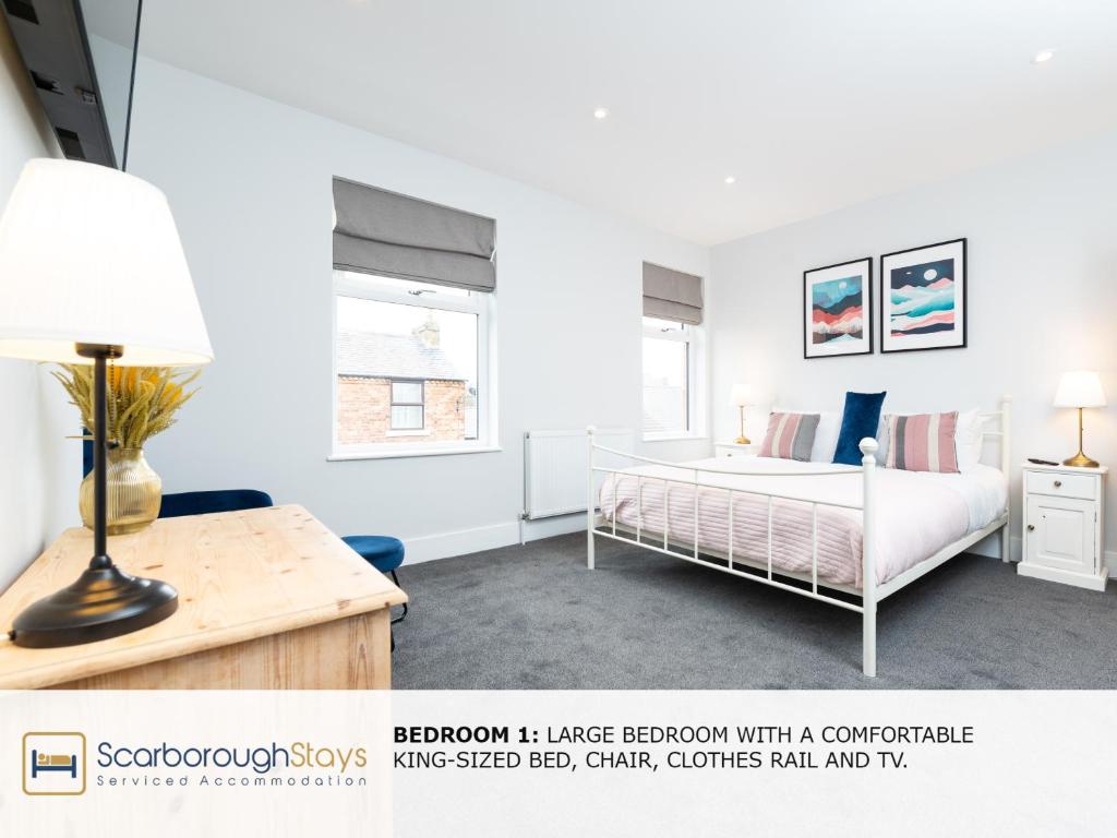 斯卡伯勒Scarborough Stays - Trafalgar Lodge - 4 bedroomed house - Free Parking的一间卧室配有一张床和一张带台灯的书桌