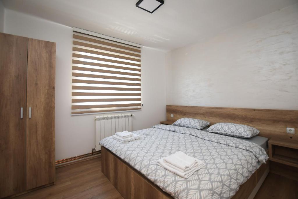 克拉多沃Zanes Apartment的一间卧室配有一张带白色床单的床和一扇窗户。